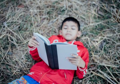 Cheerful Little Boy Reading Book